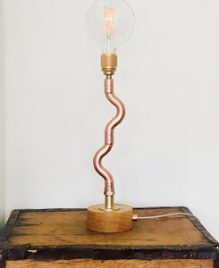 Handmade Copper pipe lamp with naked builb, oak base and quirky stem on an old tea chest